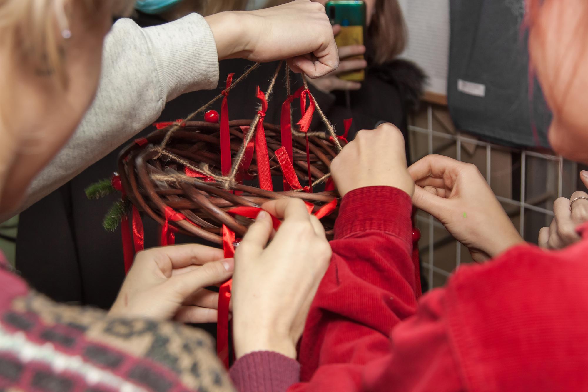 Teacher demonstrating hand stitch to a small group