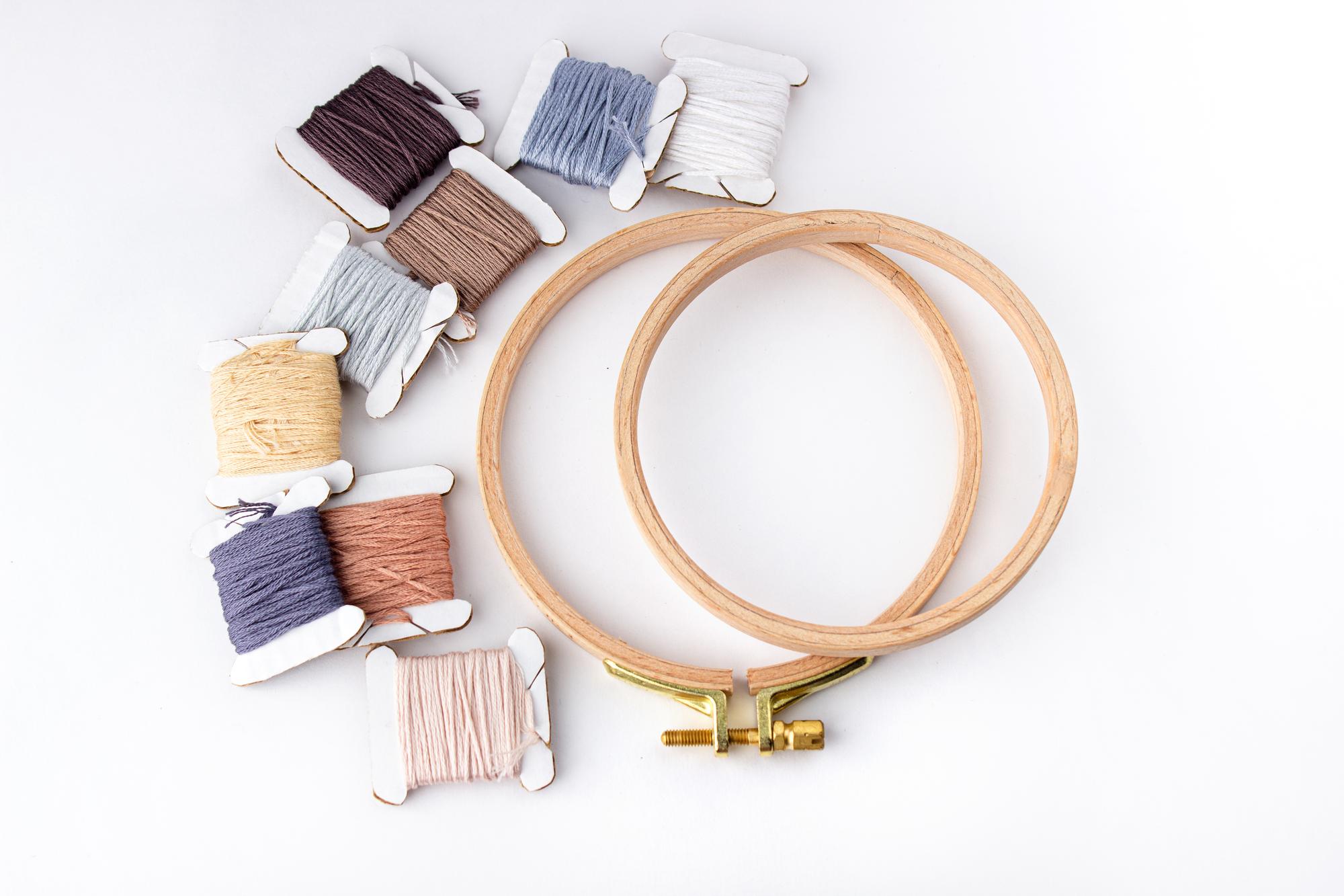Flatlay of embroidery kit with threads and hoops